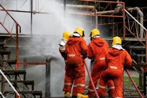 Fire fighter team on training with gas and oil fire at pipe line and valve spray jet water