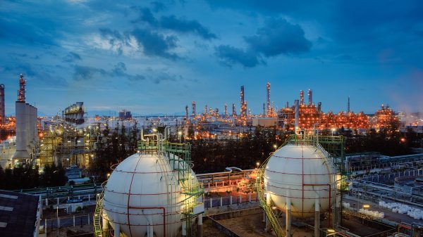 Gas storage sphere tanks and pipeline in oil and gas refinery industrial plant with glitter lighting industry estate at twilight